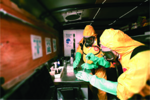 Two HAZWOPERs performing a hazard categorization to determine the class of chemical in a container.